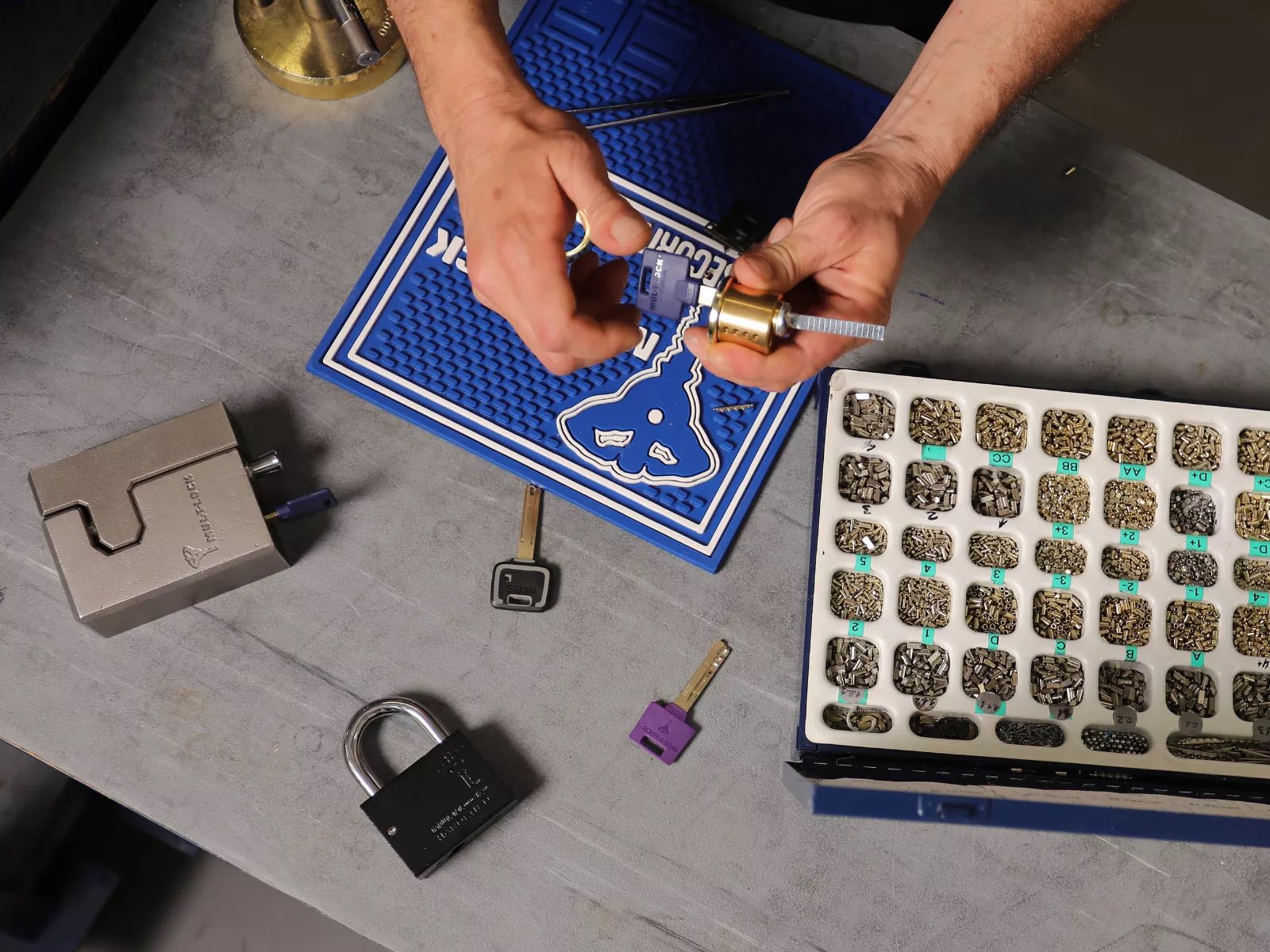 Locksmith bench with key blanks, pinning tray, and a high-security cylinder